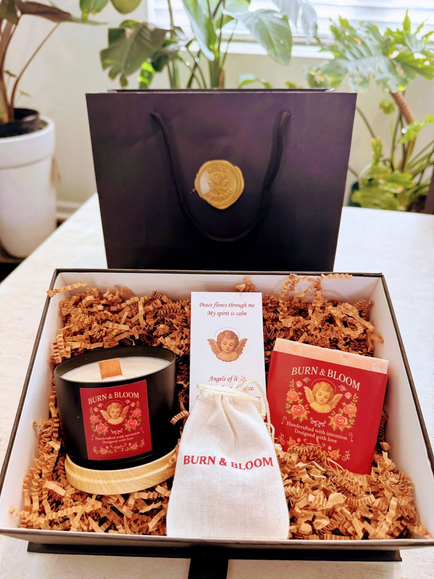A Burn & Bloom gift box with a candle, soap, sachet and card